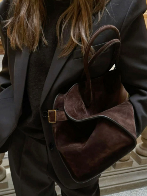 Rien de tel que l'aura chaleureuse d'un sac en daim marron pour densifier un total look noir !